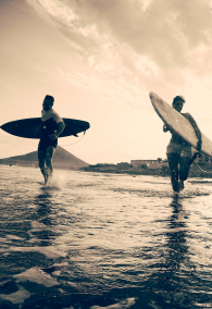 Happy surfers running with surf boards on the beach - Sporty people having fun in sunny day - Extreme sport, travel, vacation concept - Focus on left male silhouette - Black and white vintage editing